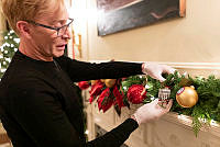 Volunteer Hangs the 2018 Official White House Christmas Ornament in the Library